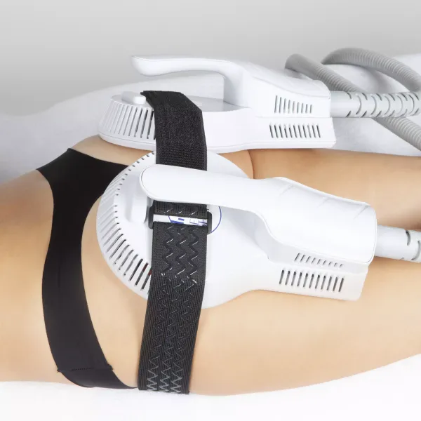 Deux pièces à main d'électrostimulation musculaire maintenues par des sangles sur le bassin et la cuisse